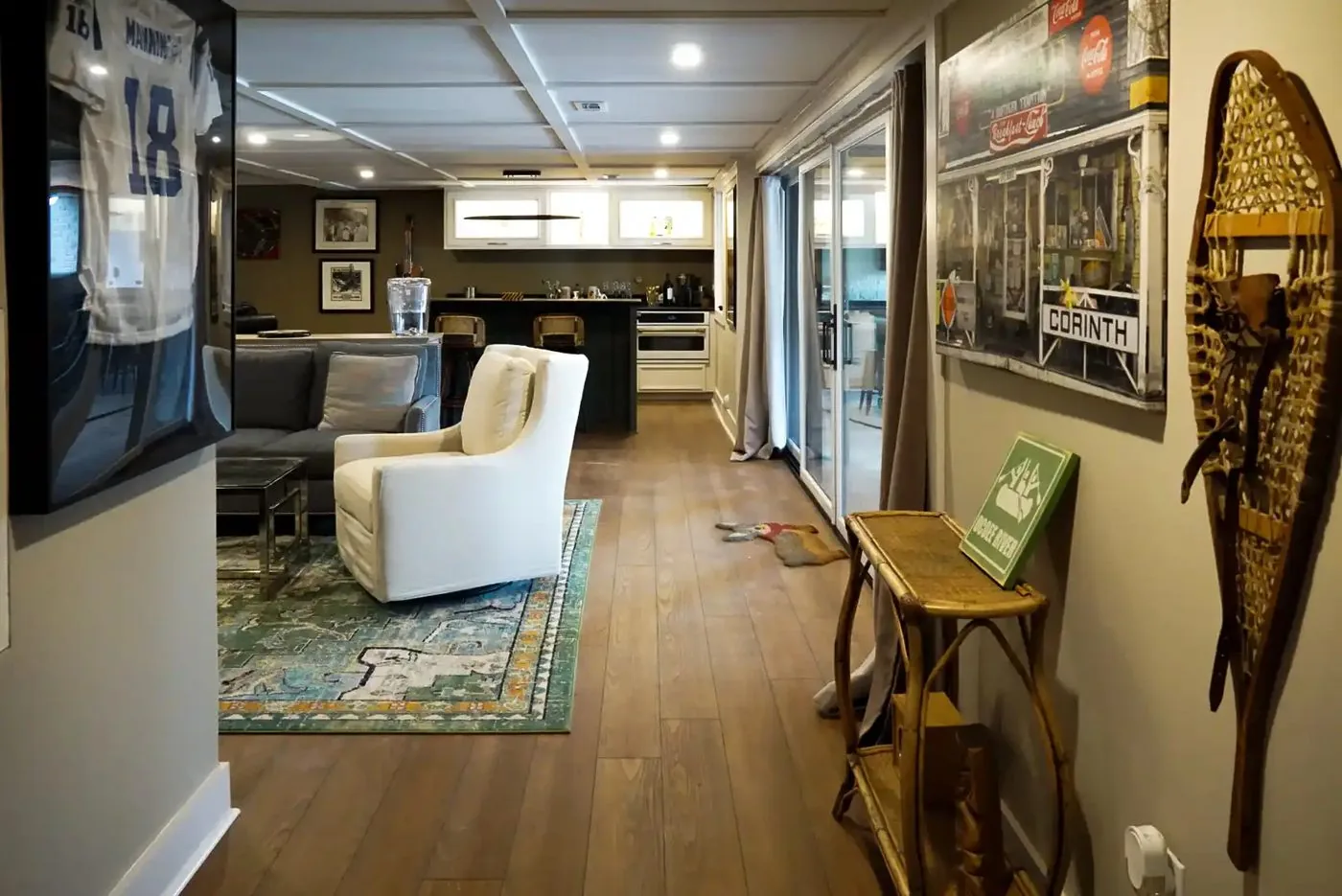 A finished basement with a built-in bar, wood floors, and a seating area